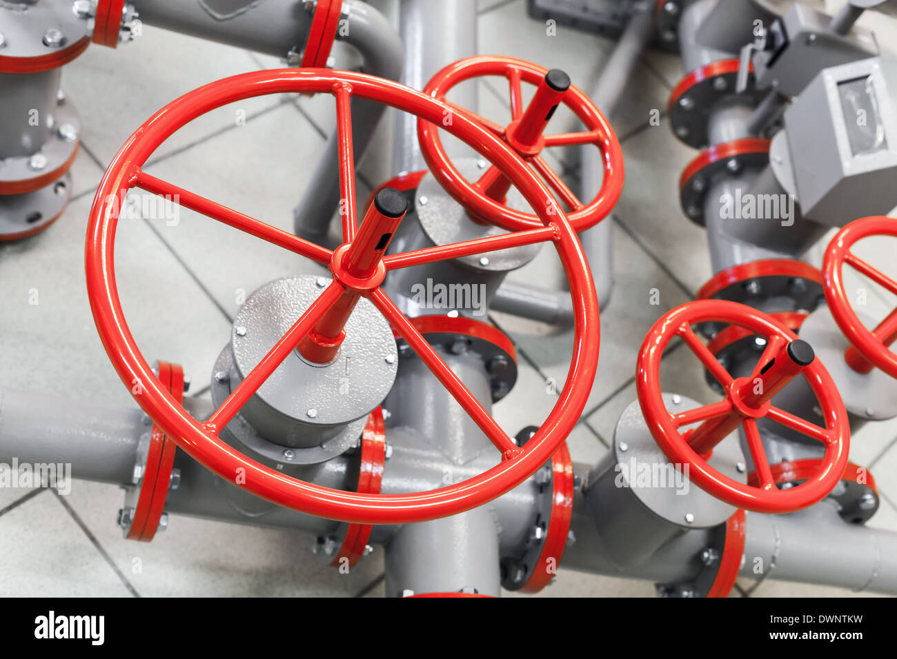 Group of red industrial valves on modern gray pipelines system Stock Photo