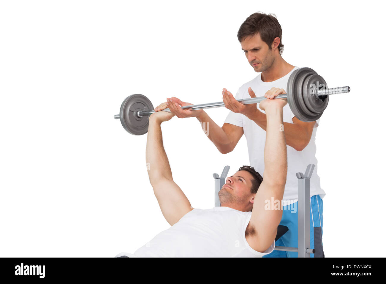 Trainer helping fit man to lift the barbell bench press Stock Photo Alamy