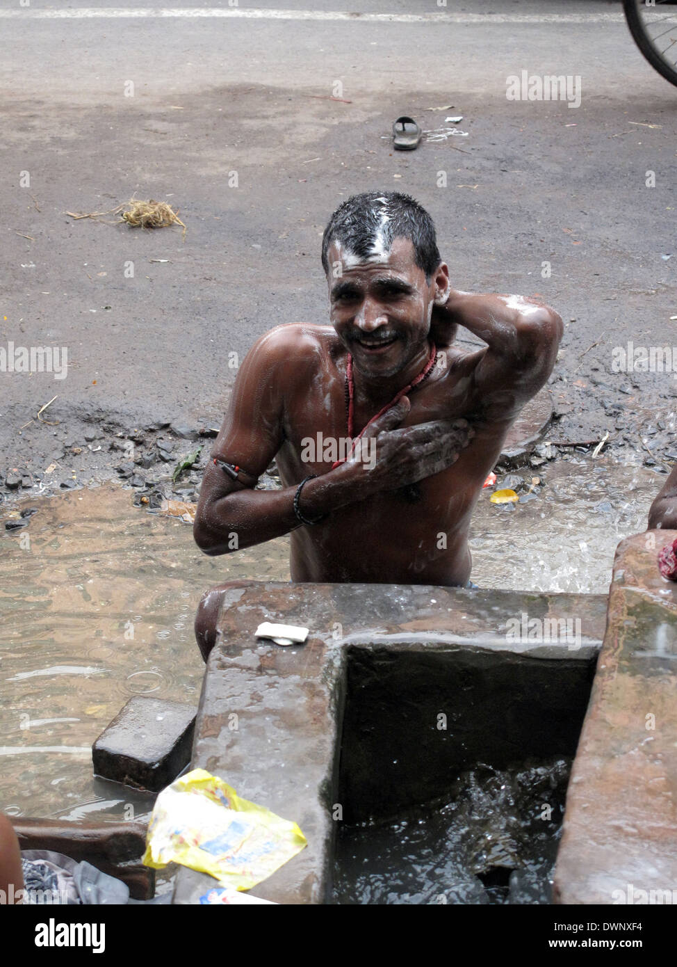 Streets of Kolkata. Indian people wash themselves on a street , January 25, 2009. Stock Photo