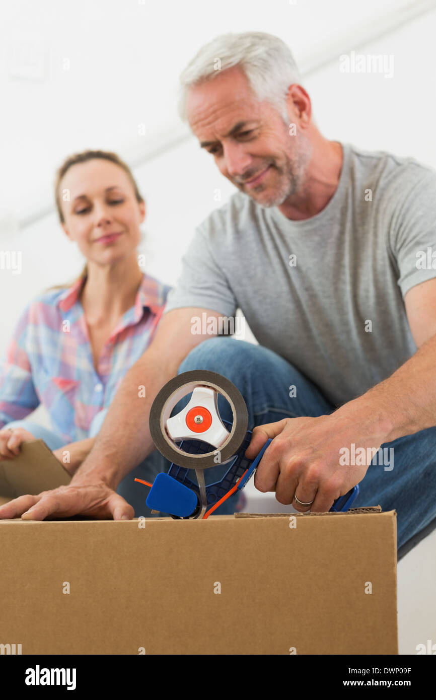 Happy couple sealing cardboard moving boxes Stock Photo Alamy
