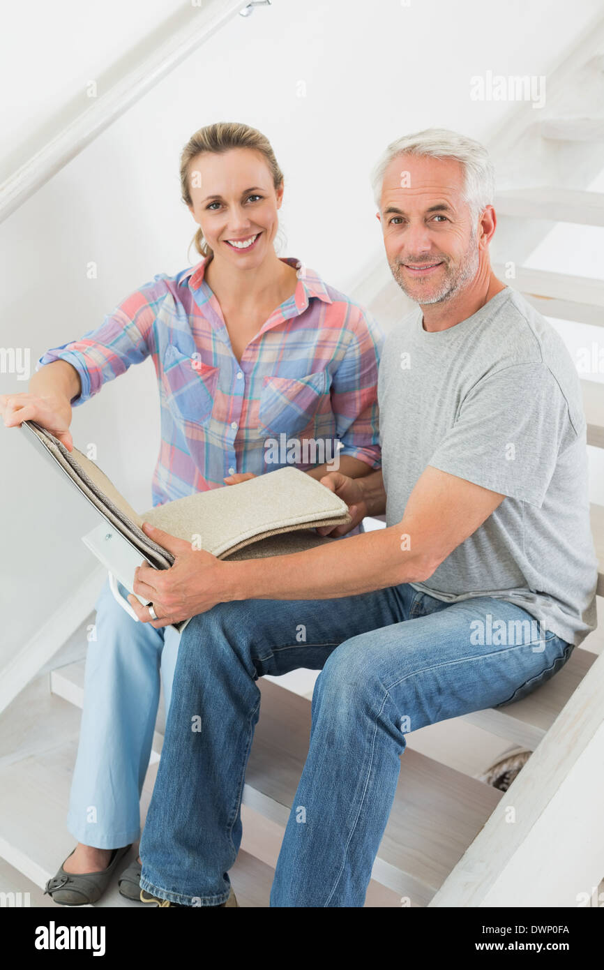Happy couple picking out carpet samples together Stock Photo Alamy