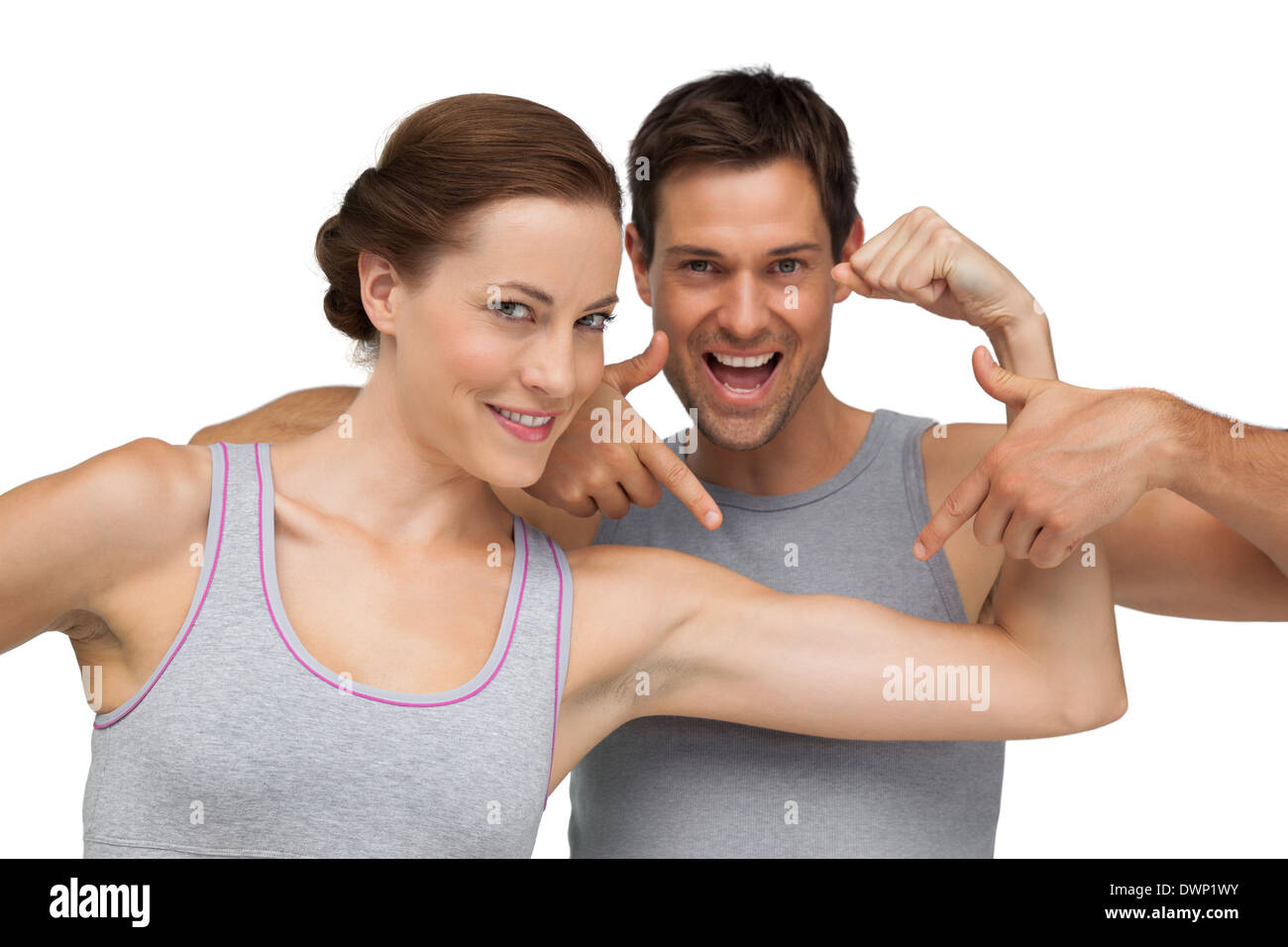 Cheerful fitness woman having fun showing biceps standing with male  athlete. Fitness couple sharing happy moments after workout. stock photo