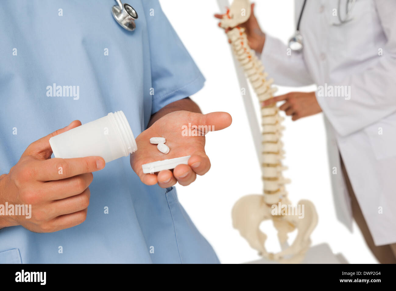 Mid section of doctors with pills and skeleton model Stock Photo