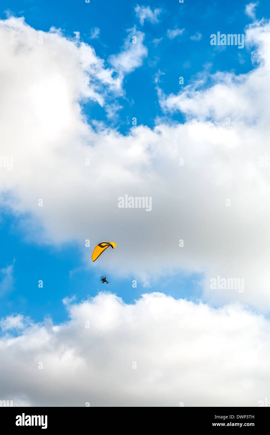 Flying paraglider on blue cloudy sky background Stock Photo