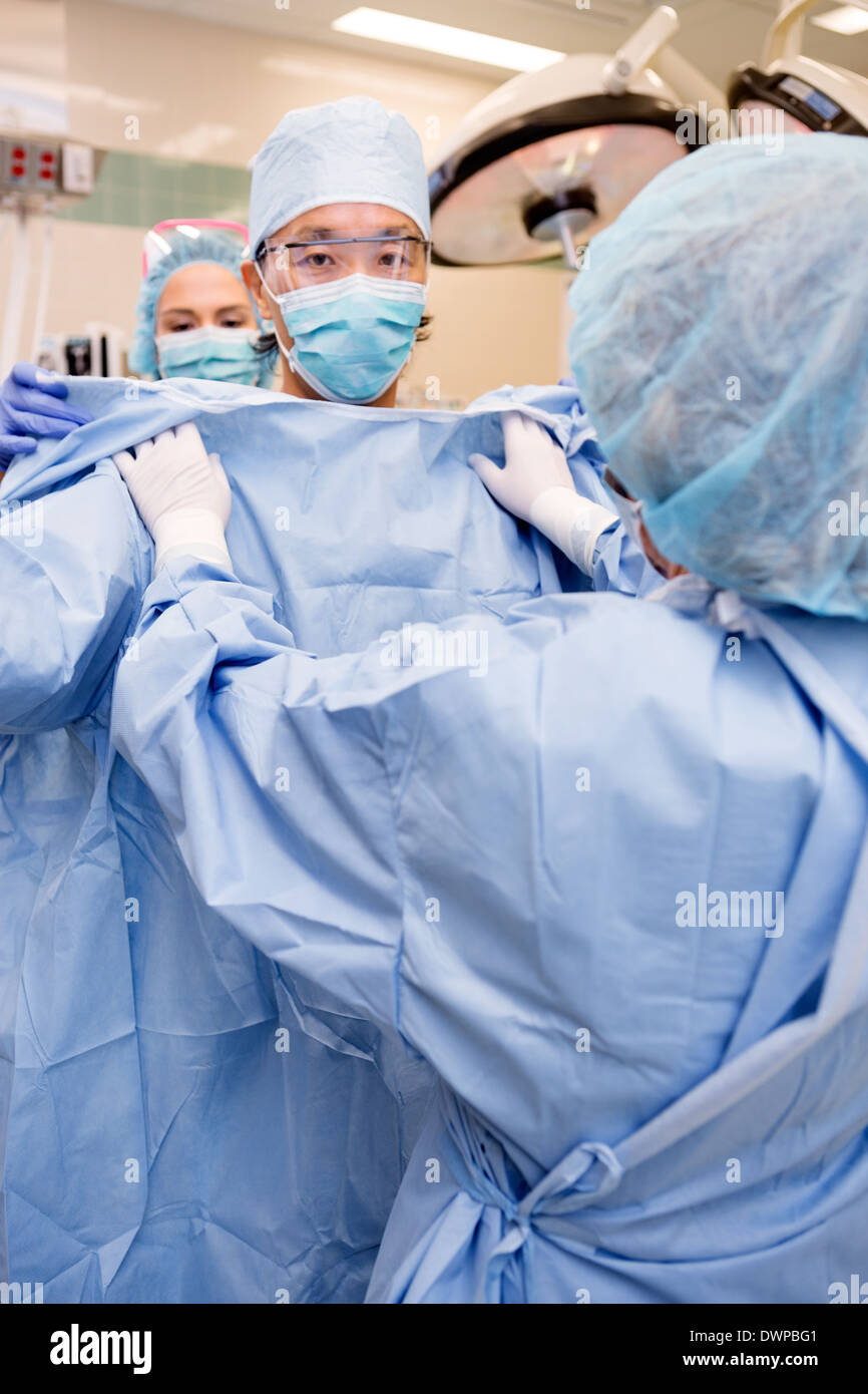 Surgeon Putting on Sterile Surgical Gown Stock Photo