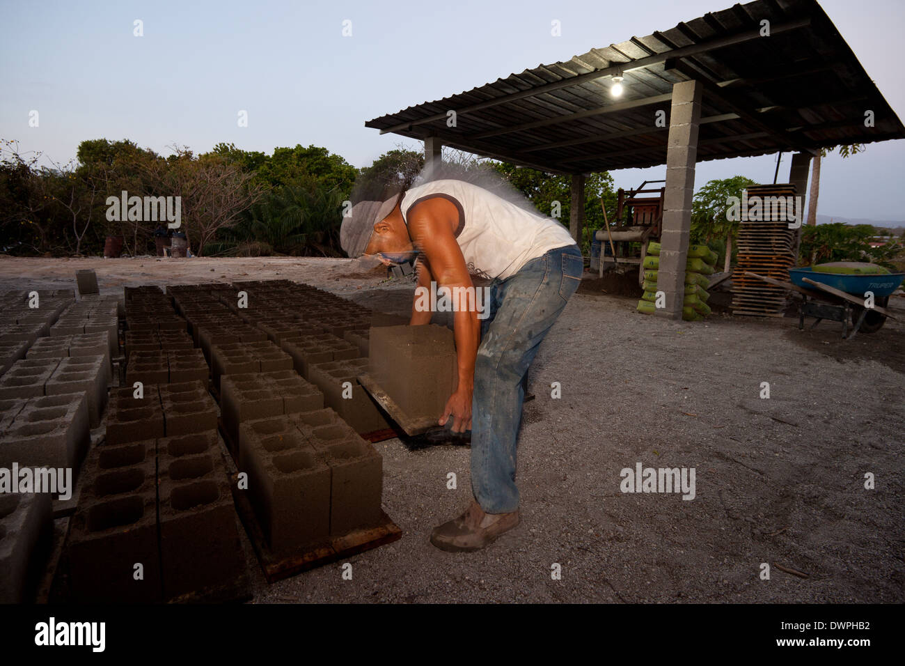 Raul Antonio Alueo, 29, carries newly pressed concrete blocks at the plant Industrias Gordon S.A in Penonome, Republic of Panama Stock Photo