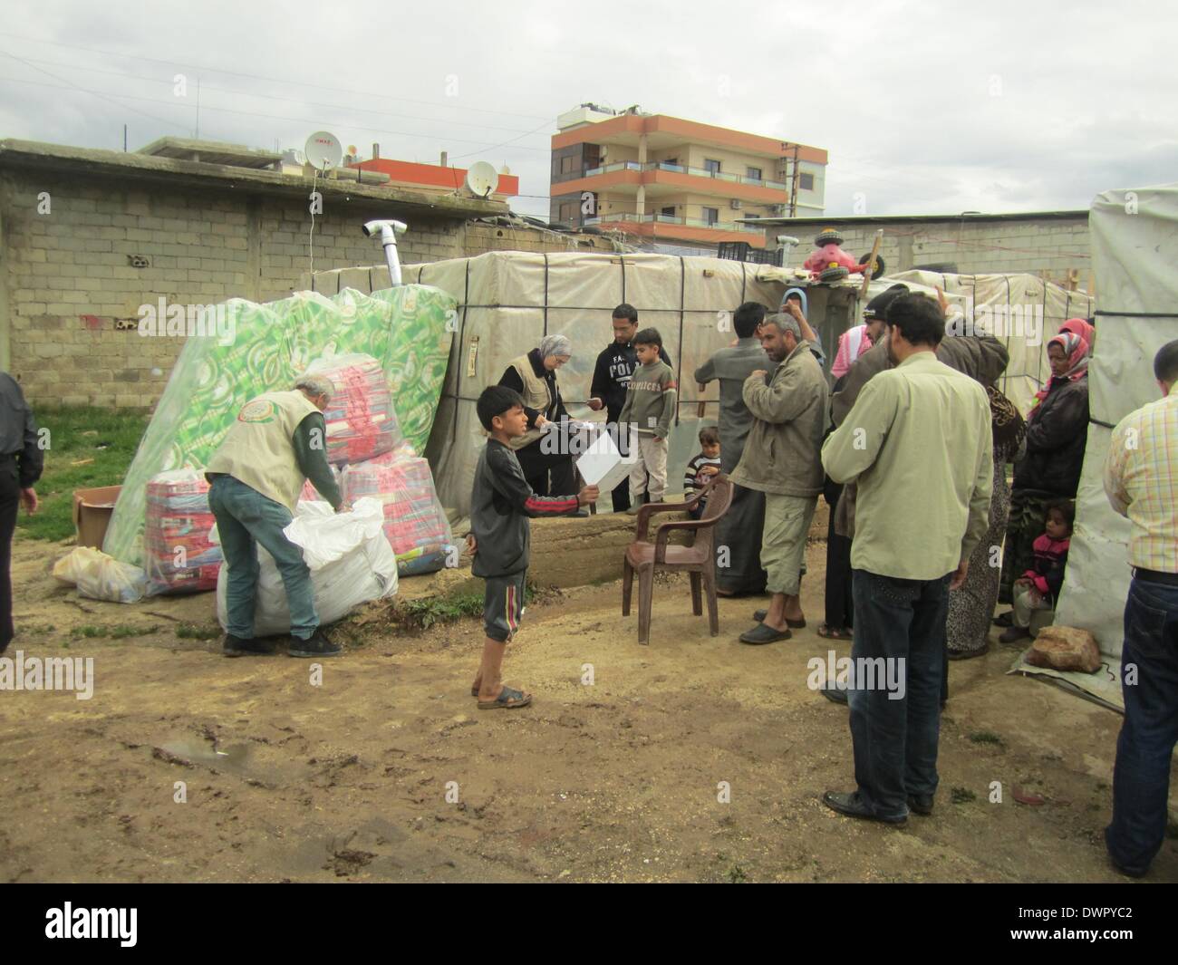 Marjayoun, Lebanon. 12th Mar, 2014. Syrian refugees receive living necessities in the refugee camp in Marjayoun, Lebanon, March 12, 2014. The Office of the United Nations High Commissioner for Refugees (UNHCR) said March 10 in its weekly report that the total number of Syrian refugees in Lebanon has reached 957,700. © Taher Abu Hamdan/Xinhua/Alamy Live News Stock Photo