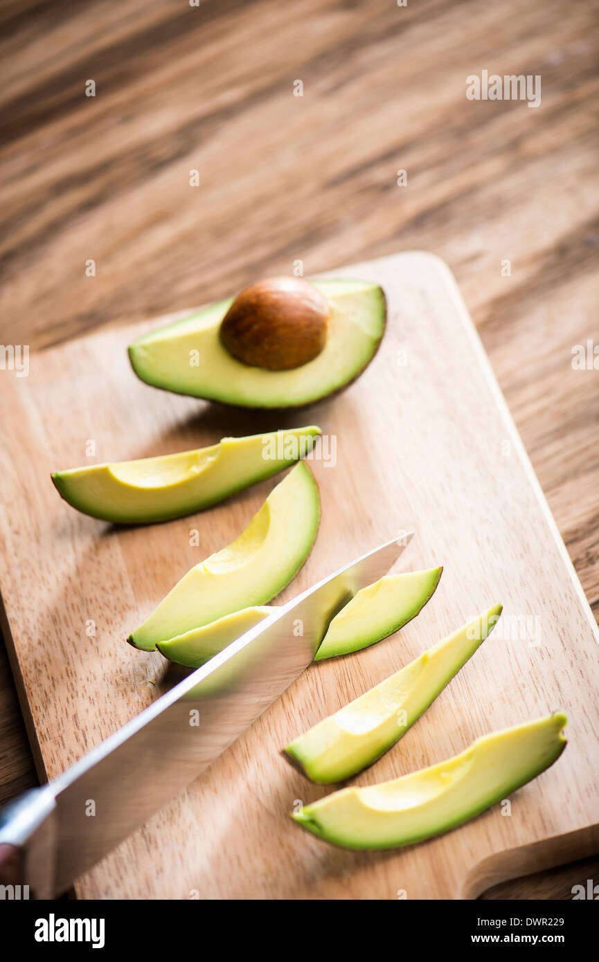 cut avocados on wooden cutting board Stock Photo - Alamy