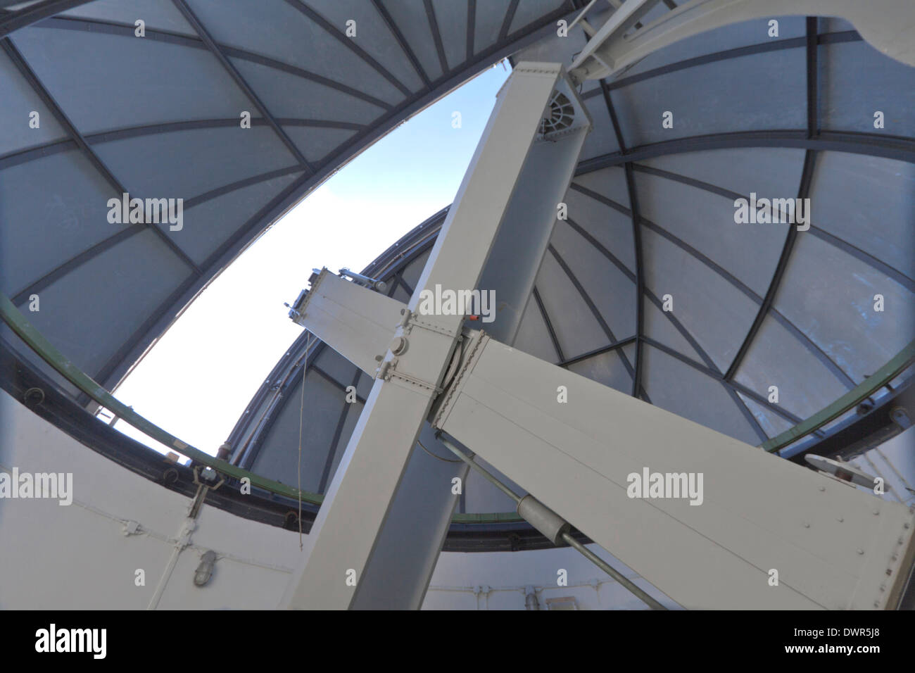 Interior view of an observatory dome and telescope pointed at the sky