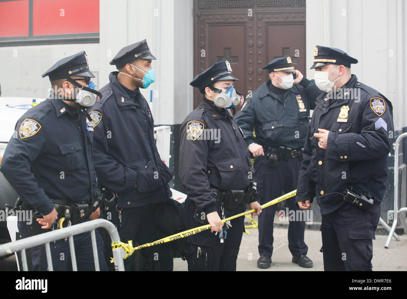 Harlem, New York City. 12 March 2014. New York City police officers wearing masks to protect against the smoky four alarm fire in Harlem. Credit:  Cal Vornberger/Alamy Live News Stock Photo