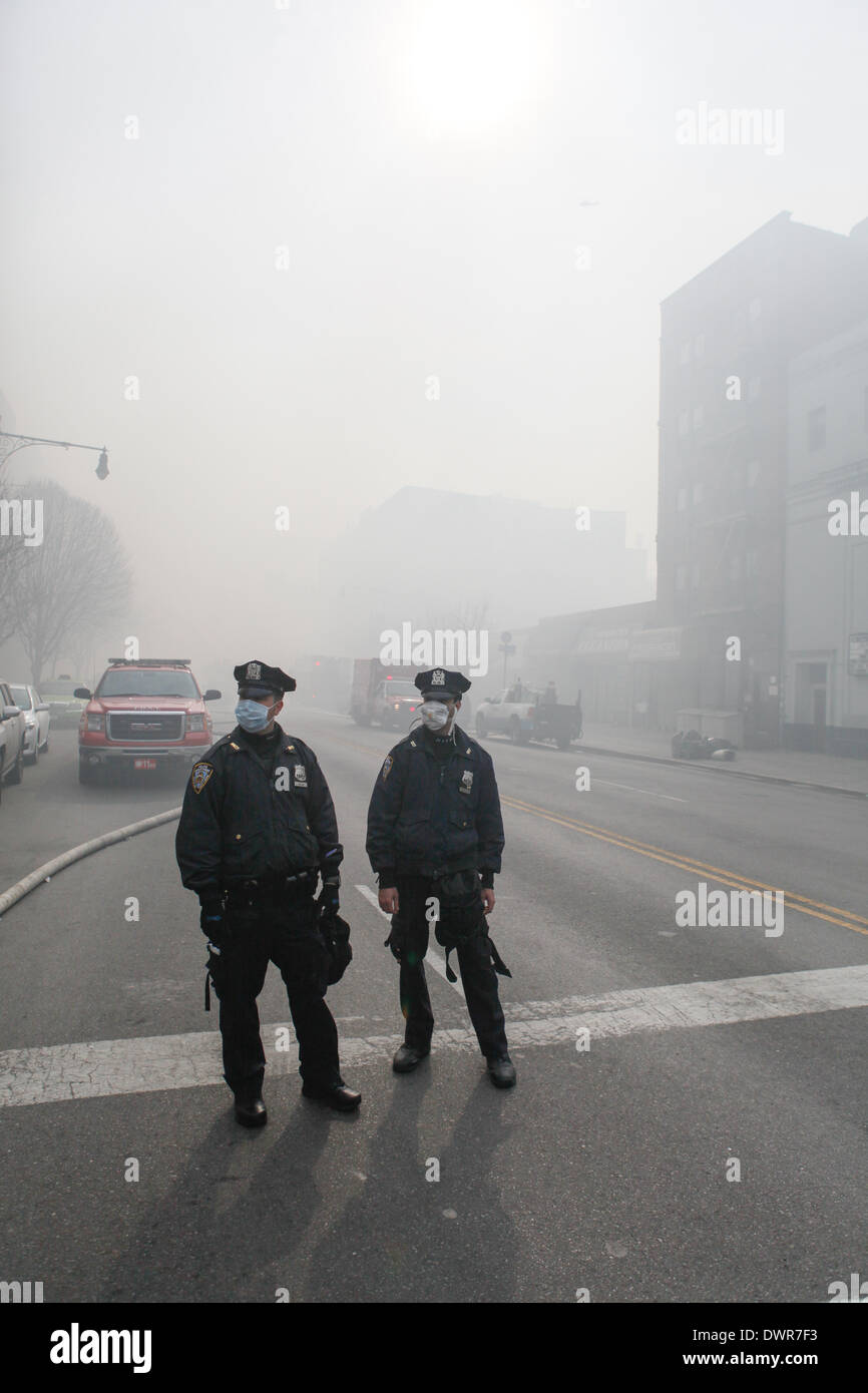 Harlem, New York City. 12 March 2014. New York City police officers wearing masks to protect against the smoky four alarm fire in Harlem. Credit:  Cal Vornberger/Alamy Live News Stock Photo