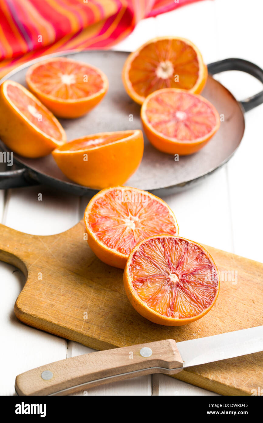 halves of red oranges on kitchen table Stock Photo