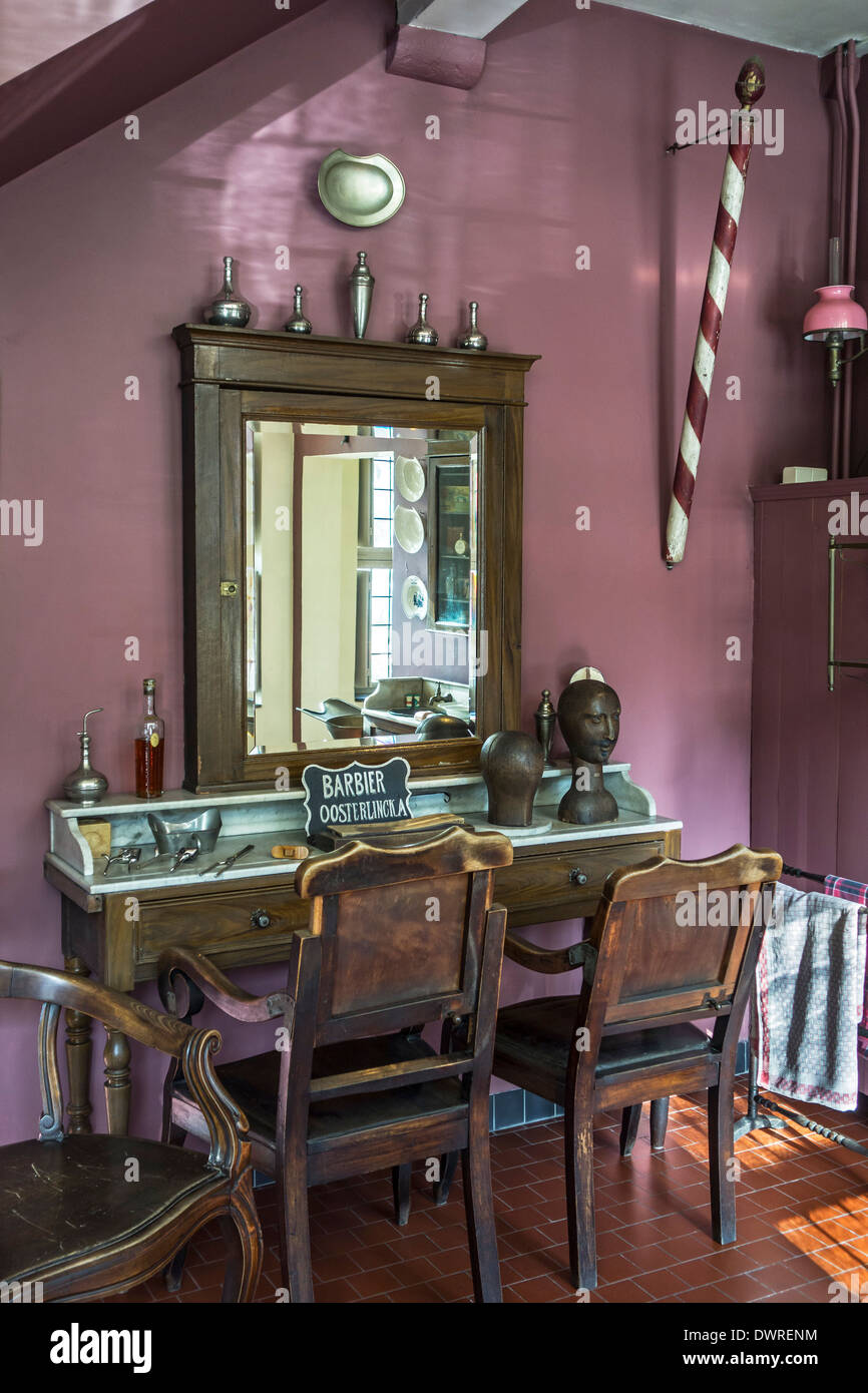 Interior of old barber's shop and barber's pole of the early twentieth century at the House of Alijn museum, Ghent, Belgium Stock Photo