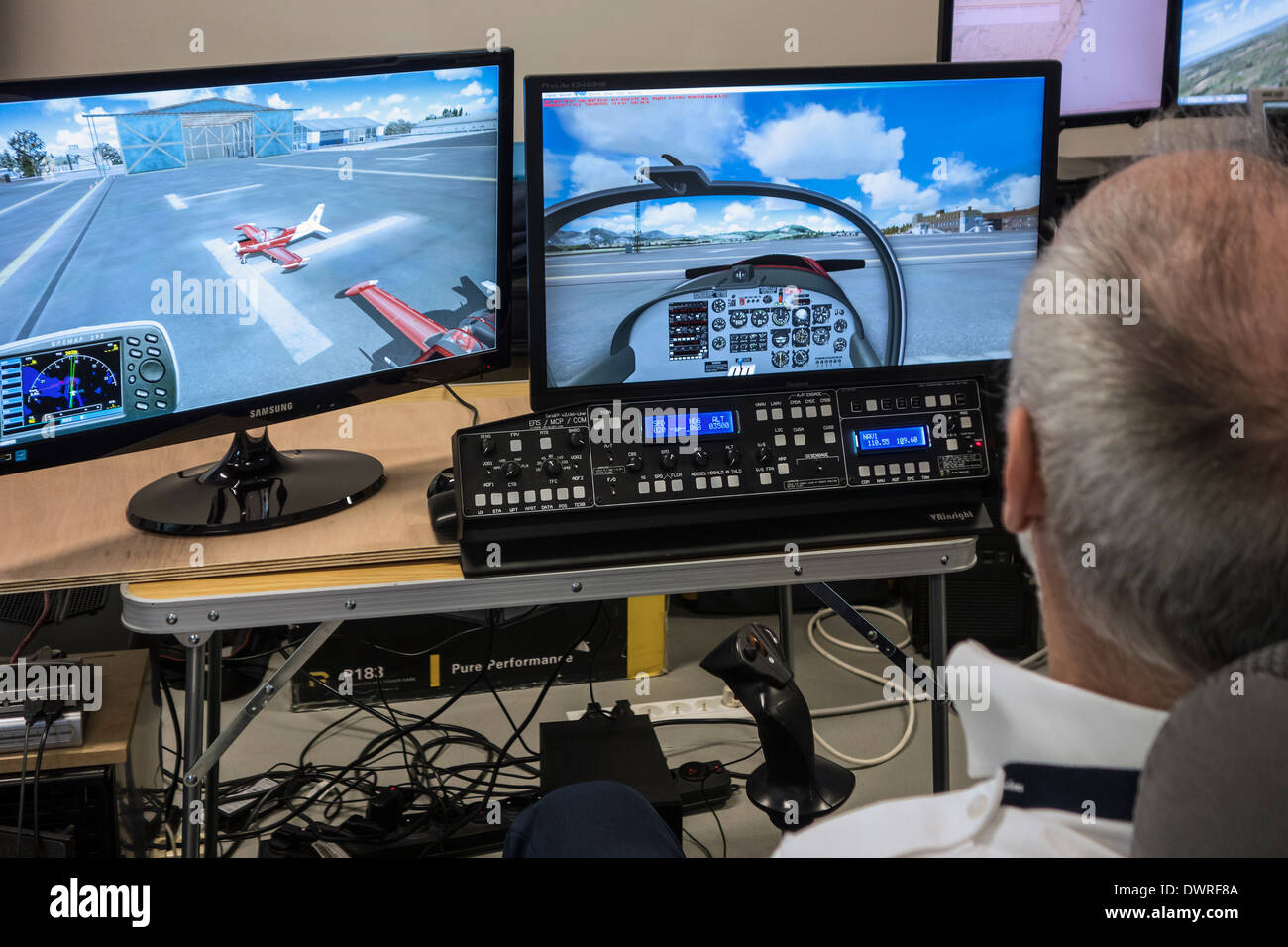 Man navigating virtual plane in amateur flight simulator on home computer Stock Photo