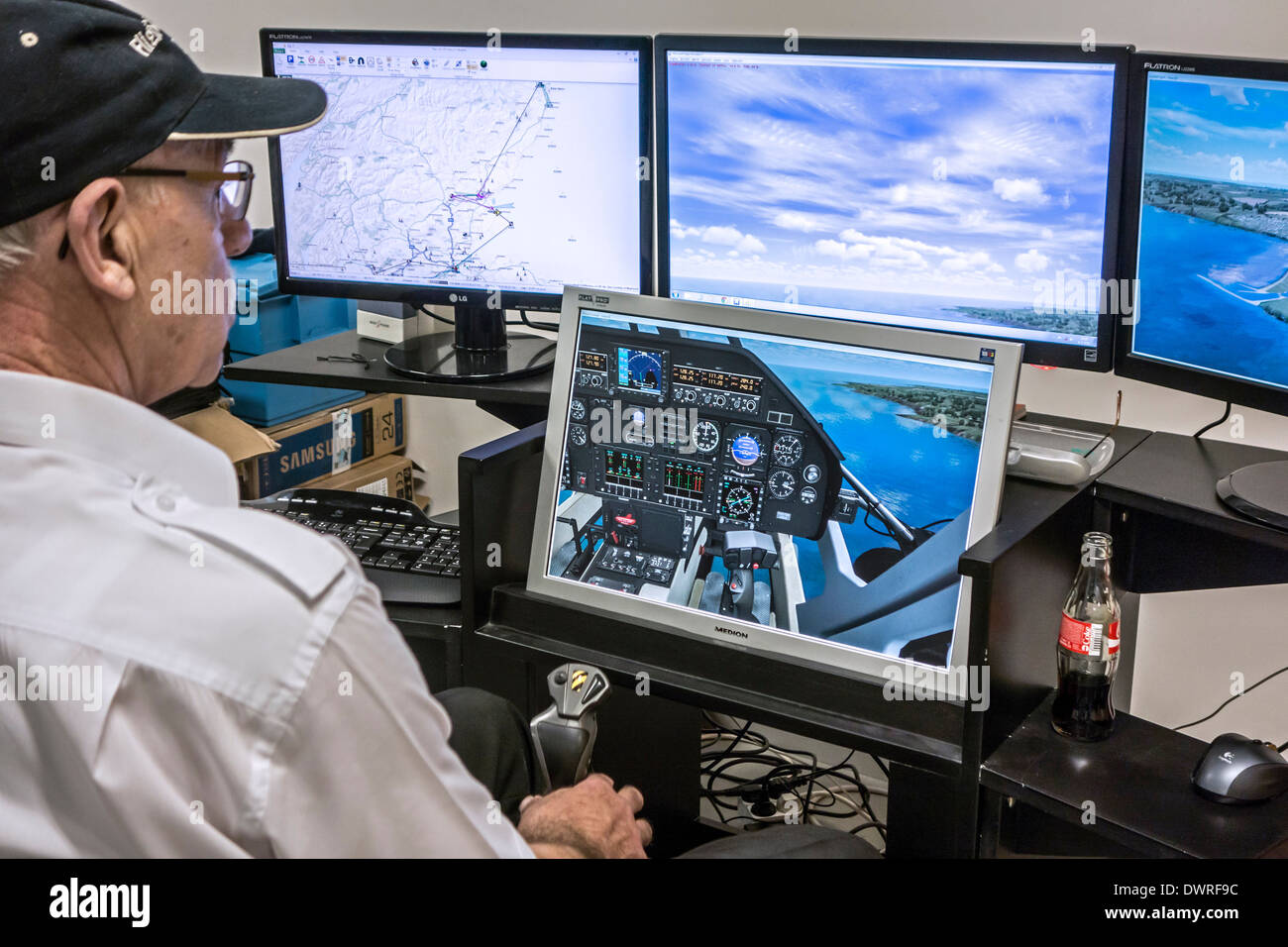 Elderly man navigating virtual airplane in amateur flight simulator on home computer Stock Photo