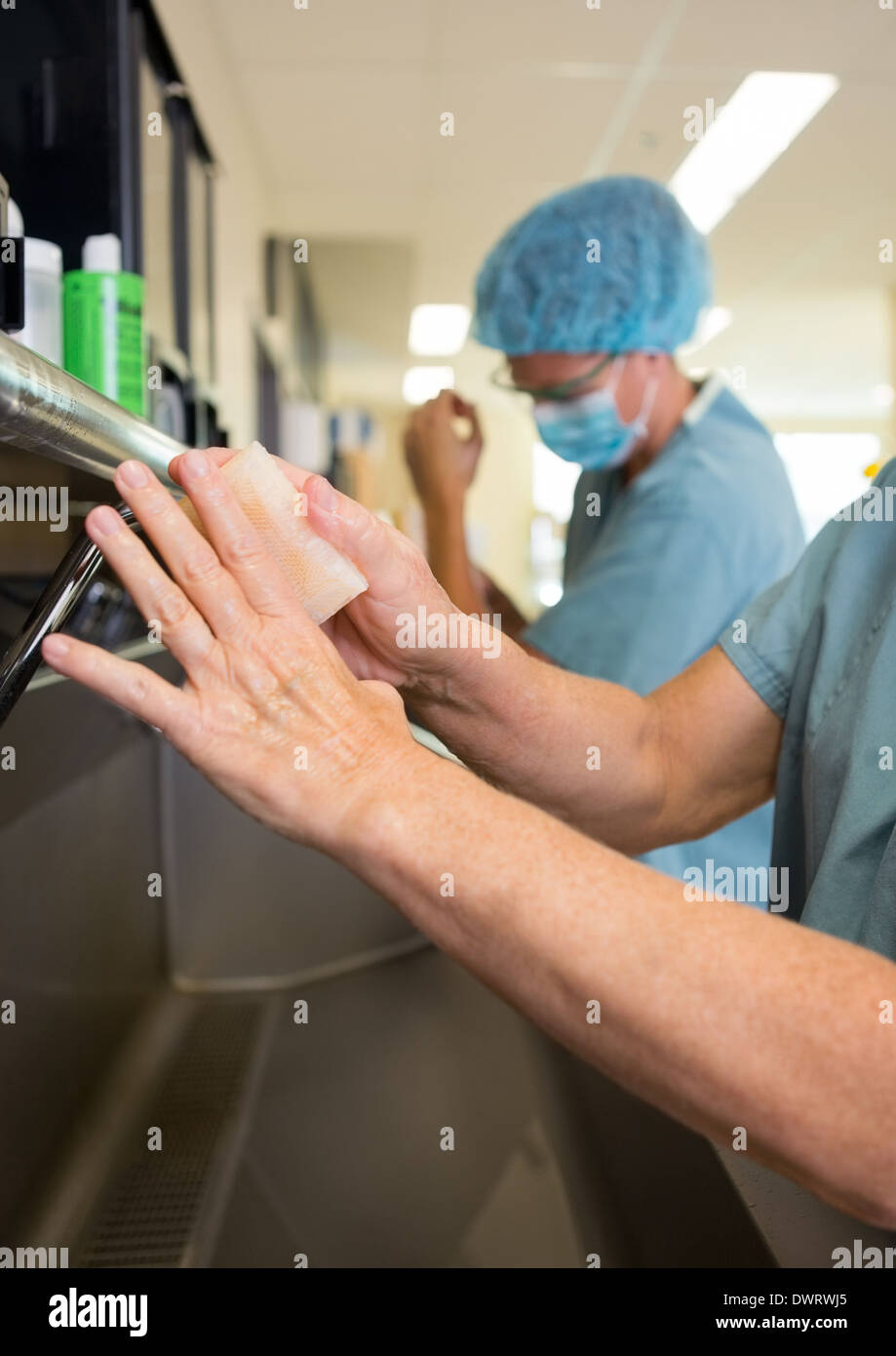 Surgeons Scrubbing Hands With Colleague Stock Photo Alamy