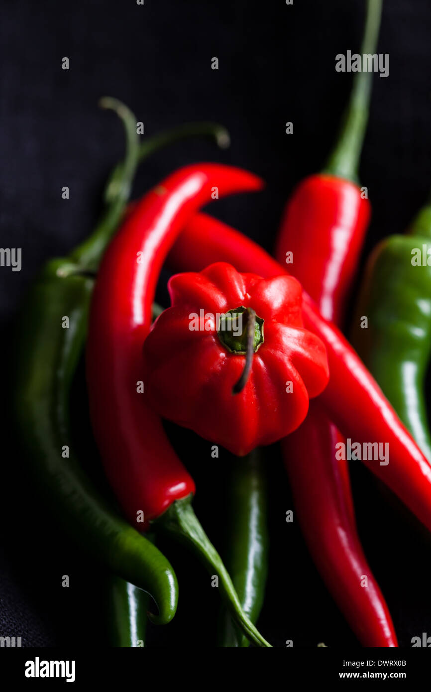 Closeup of red and green chili peppers on dark background Stock Photo