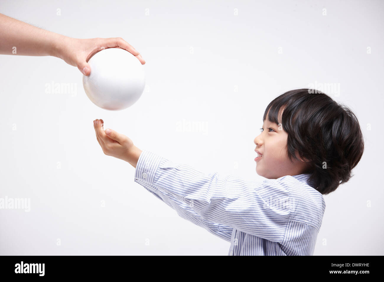 a kid receiving a ball in white background Stock Photo