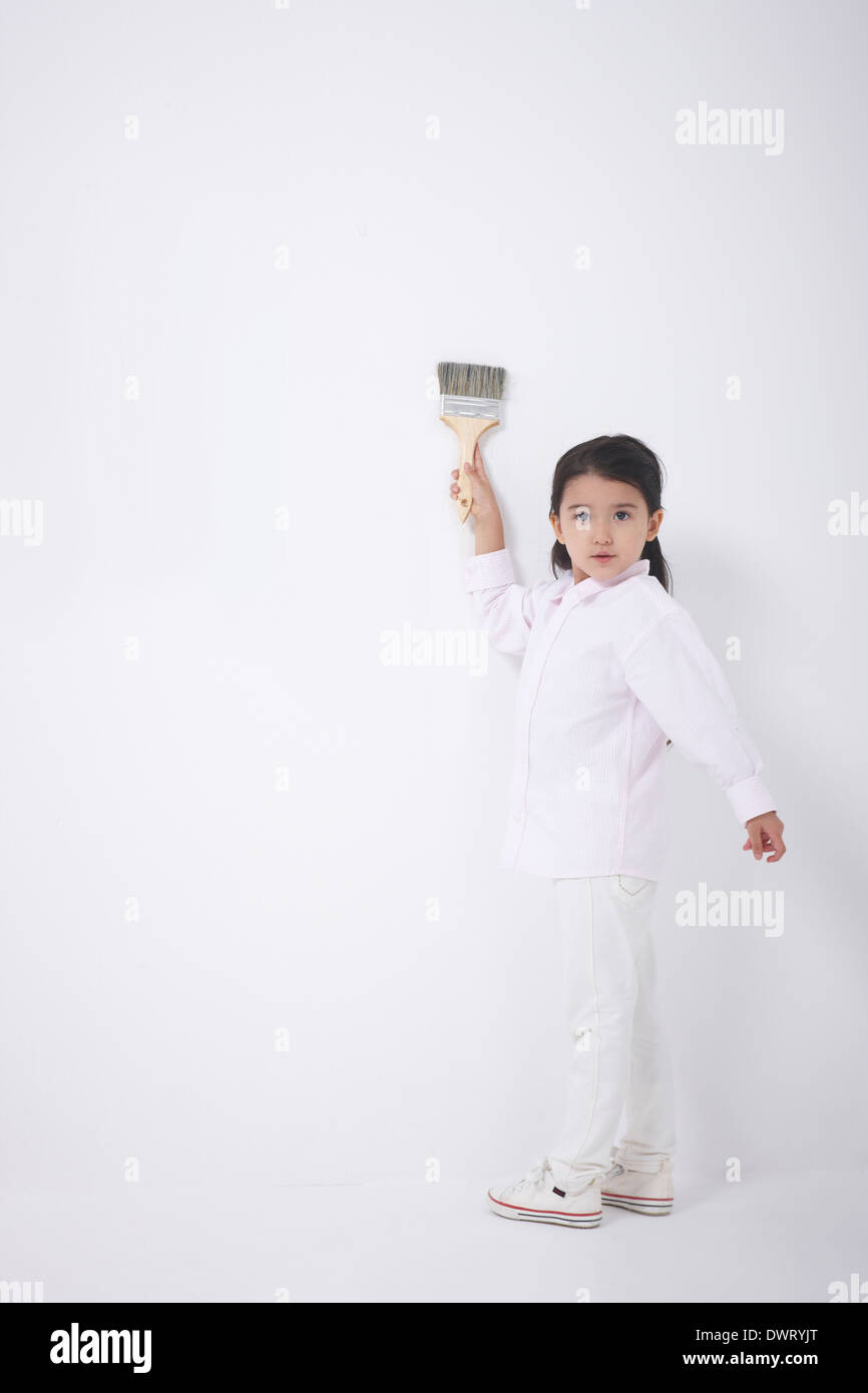 a kid painting white wall Stock Photo