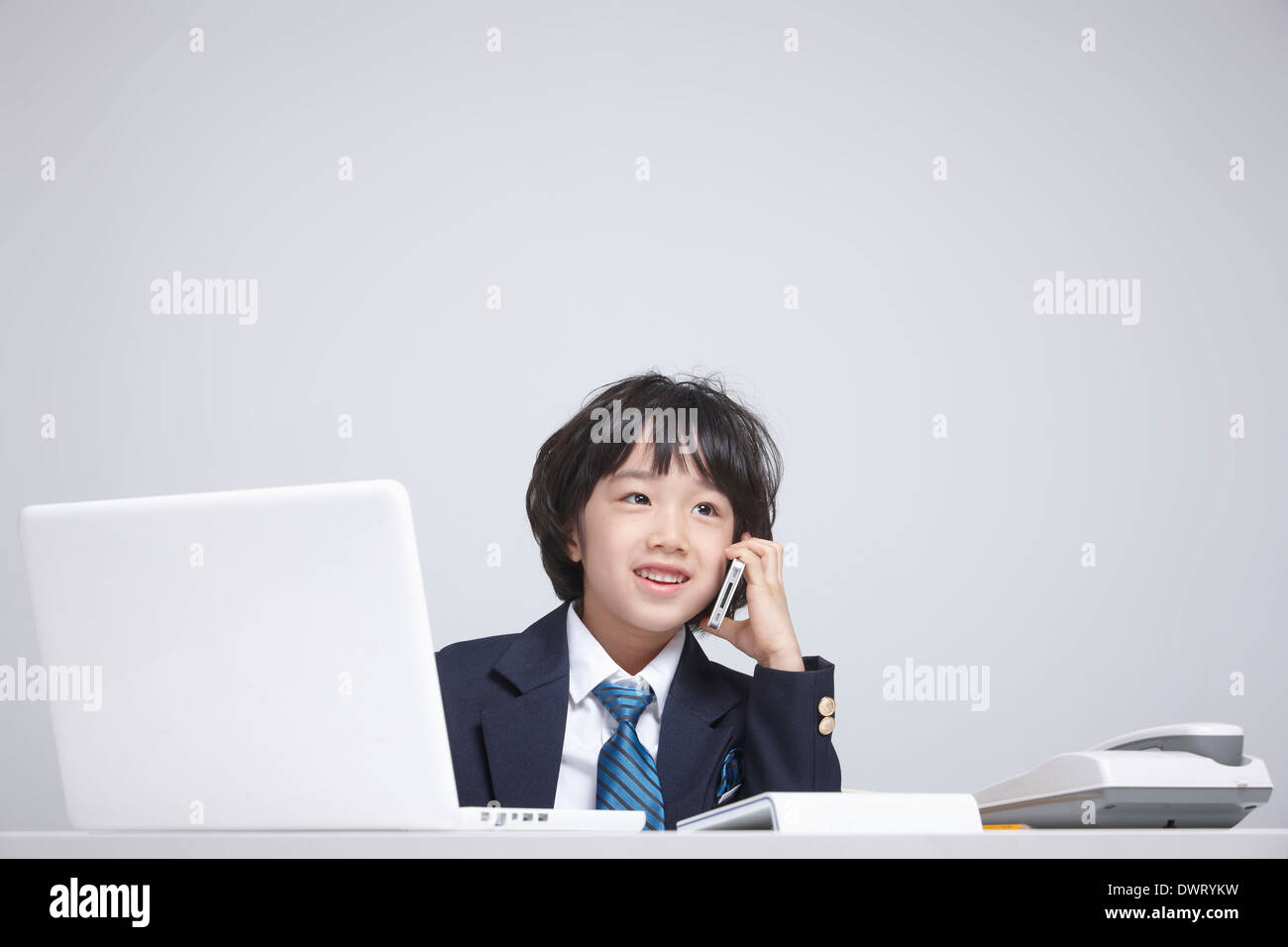 a kid wearing a business suit making a call Stock Photo