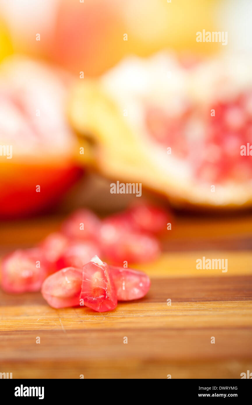 fresh pomegranate fruit over wood cutting board Stock Photo