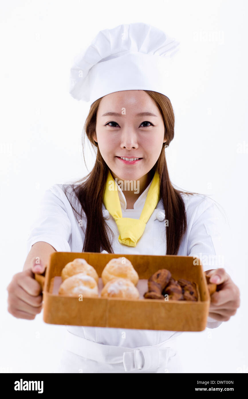 Mixed Race female pastry chef holding cake Stock Photo - Alamy