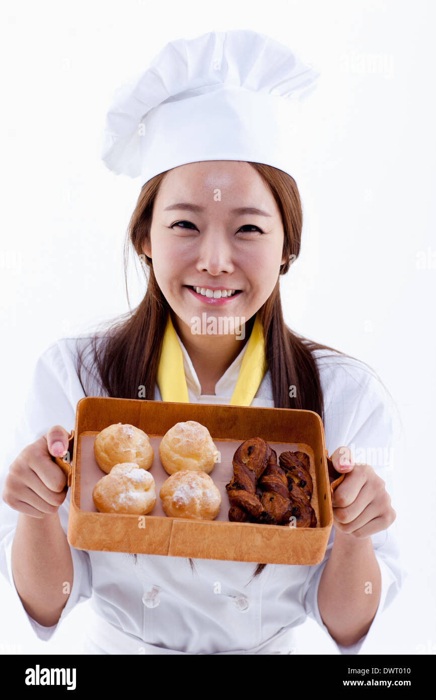 a female pastry chef holding a box with muffins Stock Photo Alamy