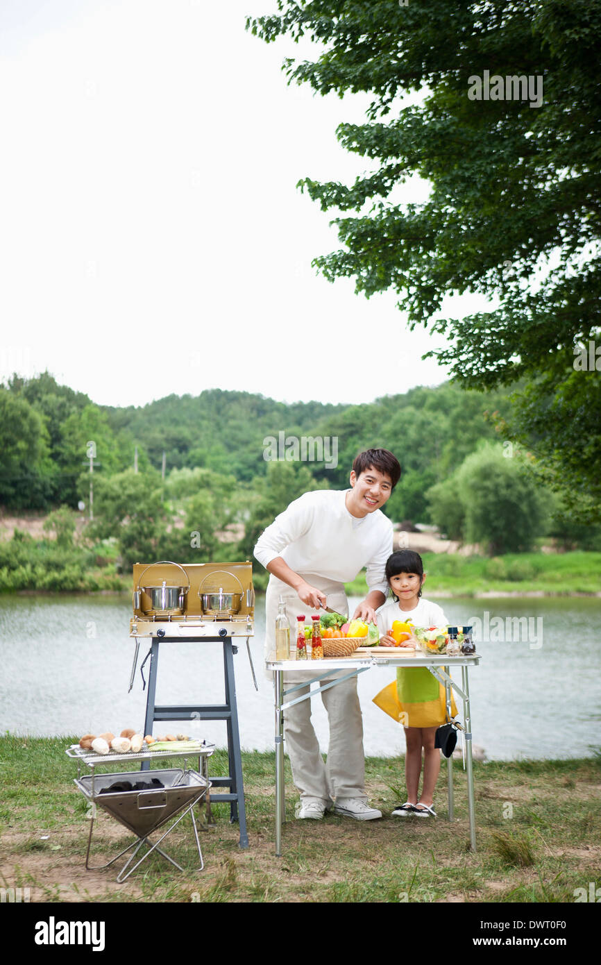 a father and daughter cooking together in camping area Stock Photo - Alamy