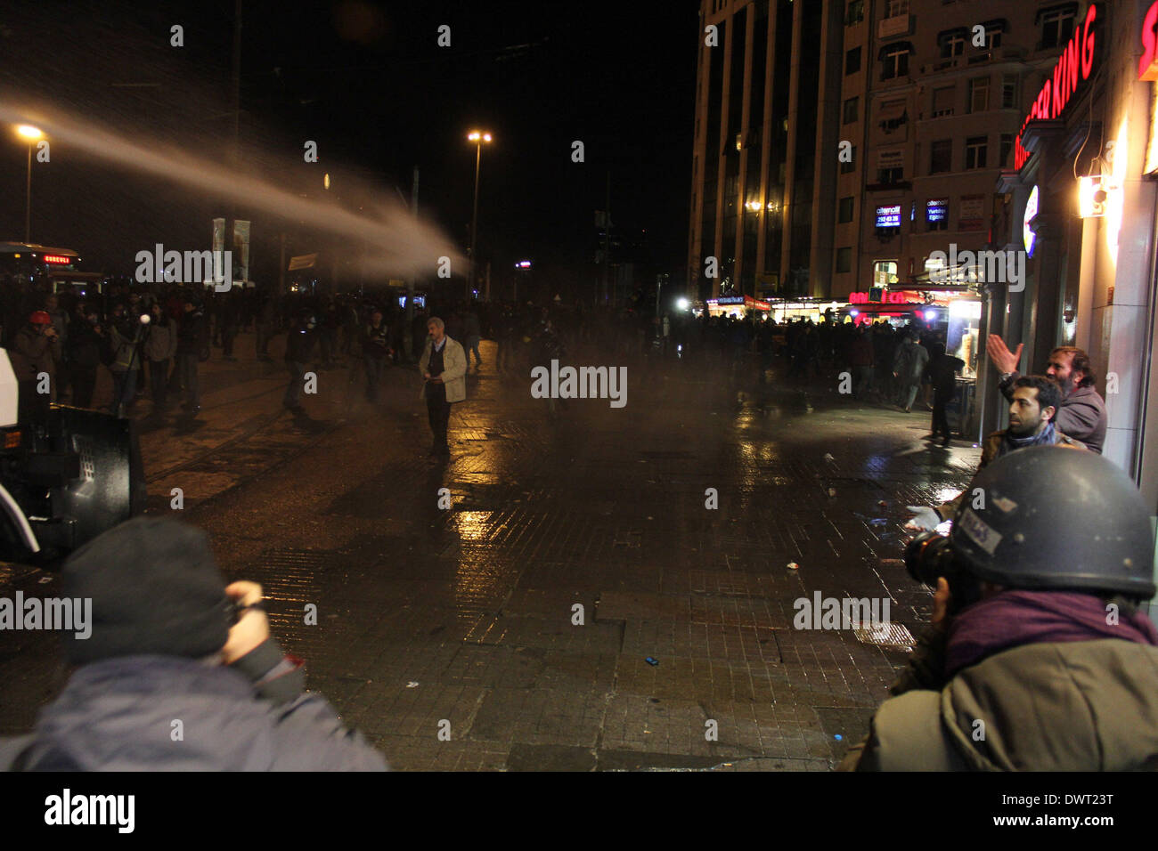 Istanbul, Turkey. 12th Mar, 2014. Riot police disperse protesters with water cannons in Istanbul, Turkey, March 12, 2014. Tension was getting high in Turkey's city of Istanbul on Wednesday as 50,000 people were flocking to a funeral of a 15-year-old student who died Tuesday after 269 days in coma. The death of Berkin Elvan has triggered a nationwide anti-government protests in more than 30 cities in Turkey. Elvan was sent into a coma after sustaining a head injury from a gas canister as he went to buy bread during a police crackdown in Istanbul last June. Credit:  Cihan/Xinhua/Alamy Live News Stock Photo
