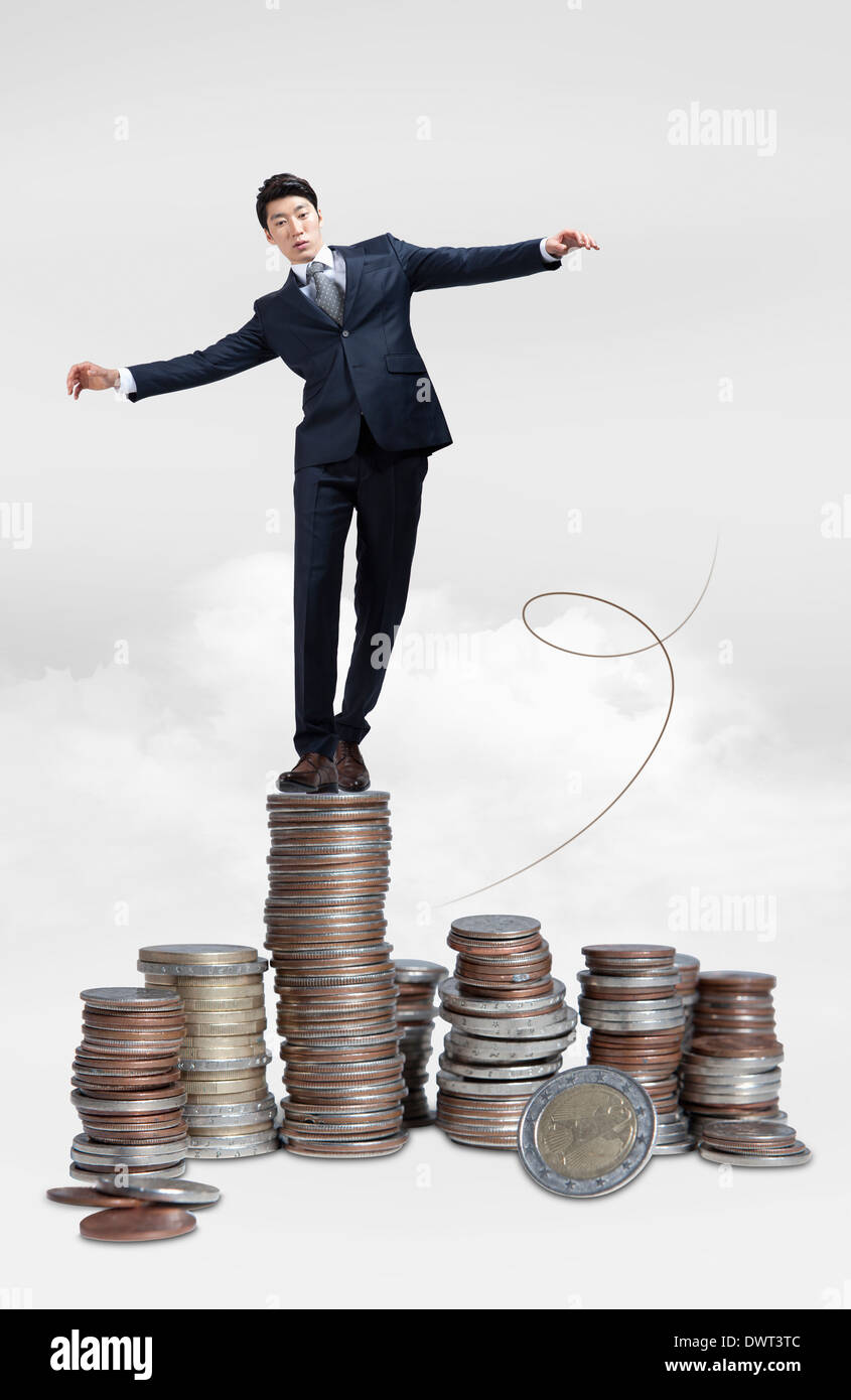 a business man standing on piles of coins Stock Photo - Alamy