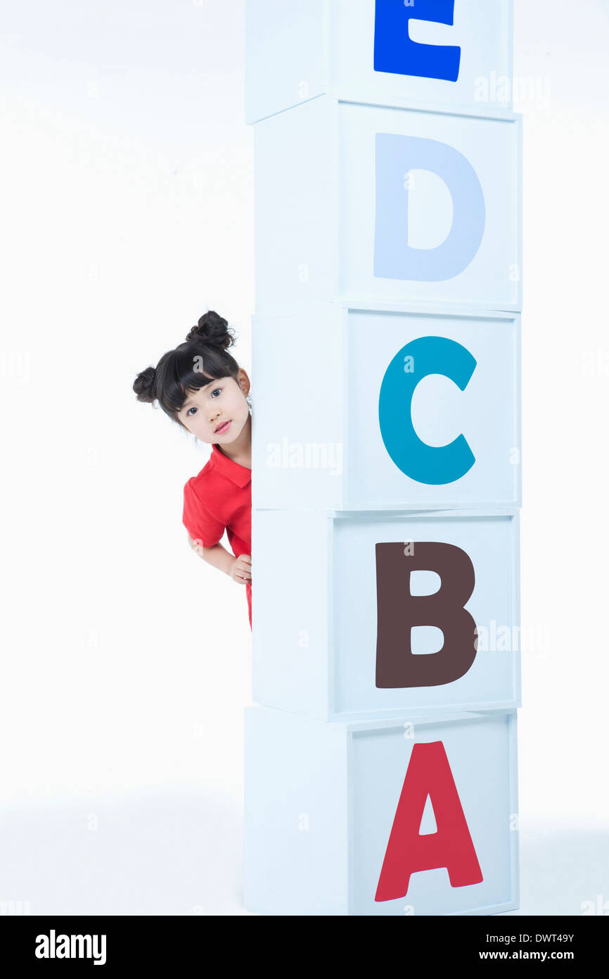 a kid hiding behind a pile of alphabet blocks Stock Photo - Alamy