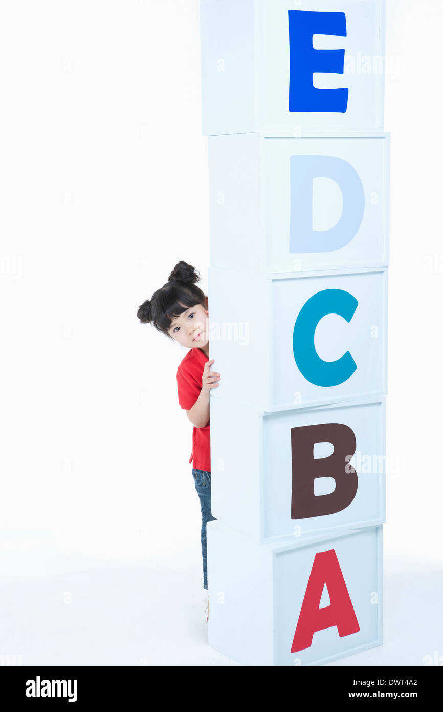 a kid hiding behind a pile of alphabet blocks Stock Photo - Alamy