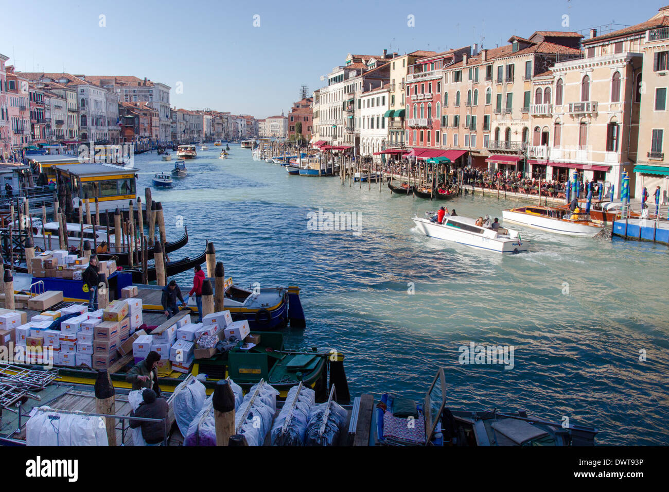 Canal barges unload supplies for merchants along the Grand Canal on a beautiful morning. Stock Photo