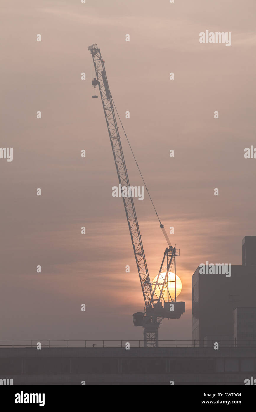 LONDON, UK, 13th Mar, 2014. London starts the day swathed in a blanket of fog. The sun rises behind a crane near St Thomas' Hospital, Westminster Credit:  Steve Bright/Alamy Live News Stock Photo