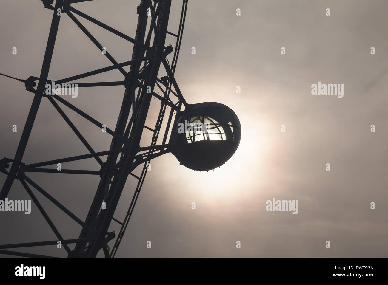 LONDON, UK, 13th Mar, 2014. London starts the day swathed in a blanket of fog. The rising sun is directly illuminating one of the pods on the London Eye. Credit:  Steve Bright/Alamy Live News Stock Photo