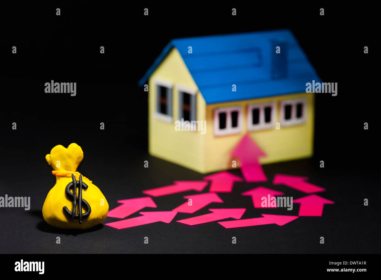 arrows pointing from money bag to house Stock Photo