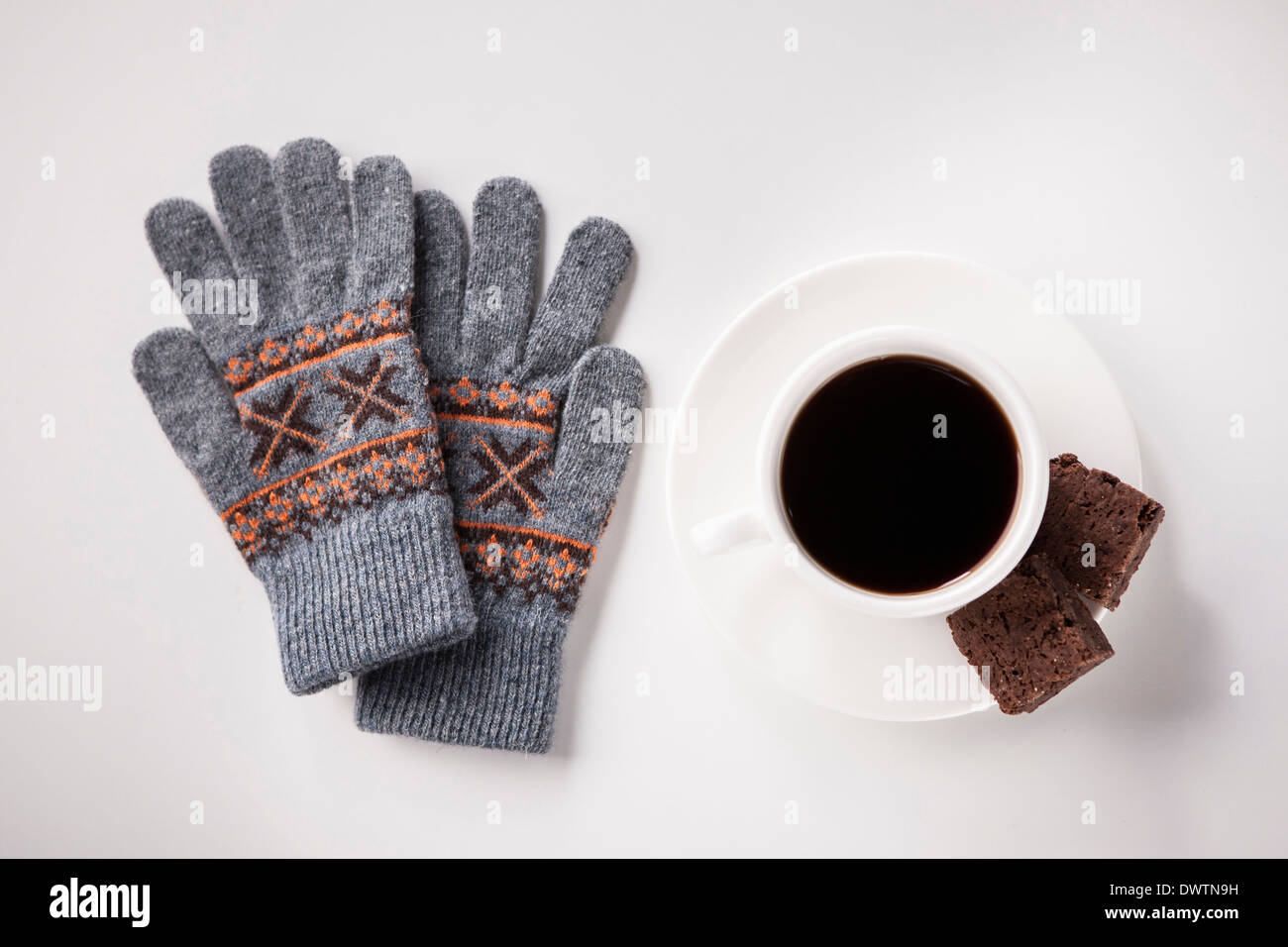 a cup of coffee next to a pair of gloves Stock Photo - Alamy