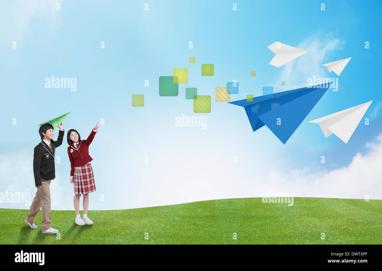 a boy and a girl throwing paper planes Stock Photo - Alamy