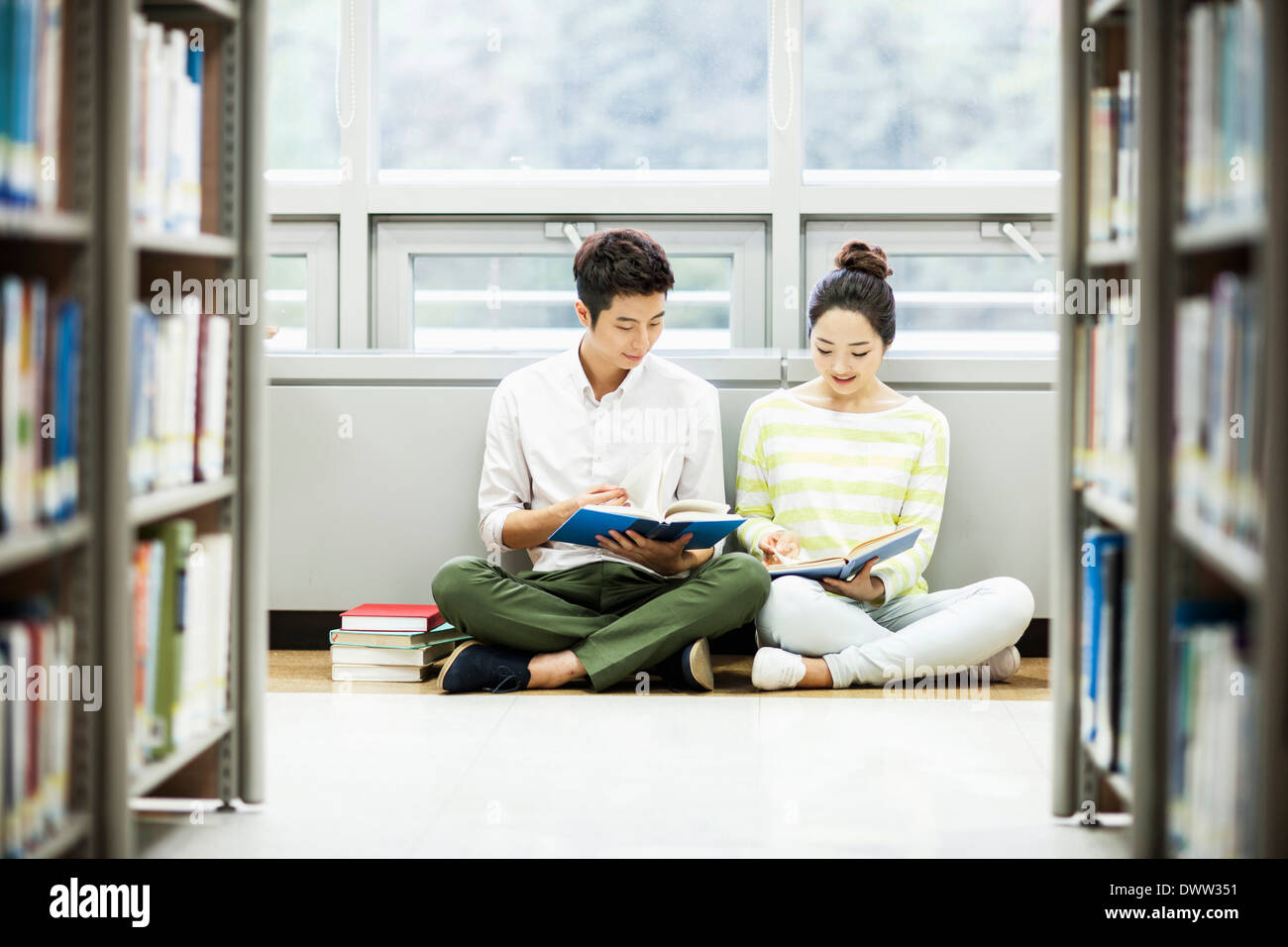 a boy and a girl reading in the library Stock Photo - Alamy
