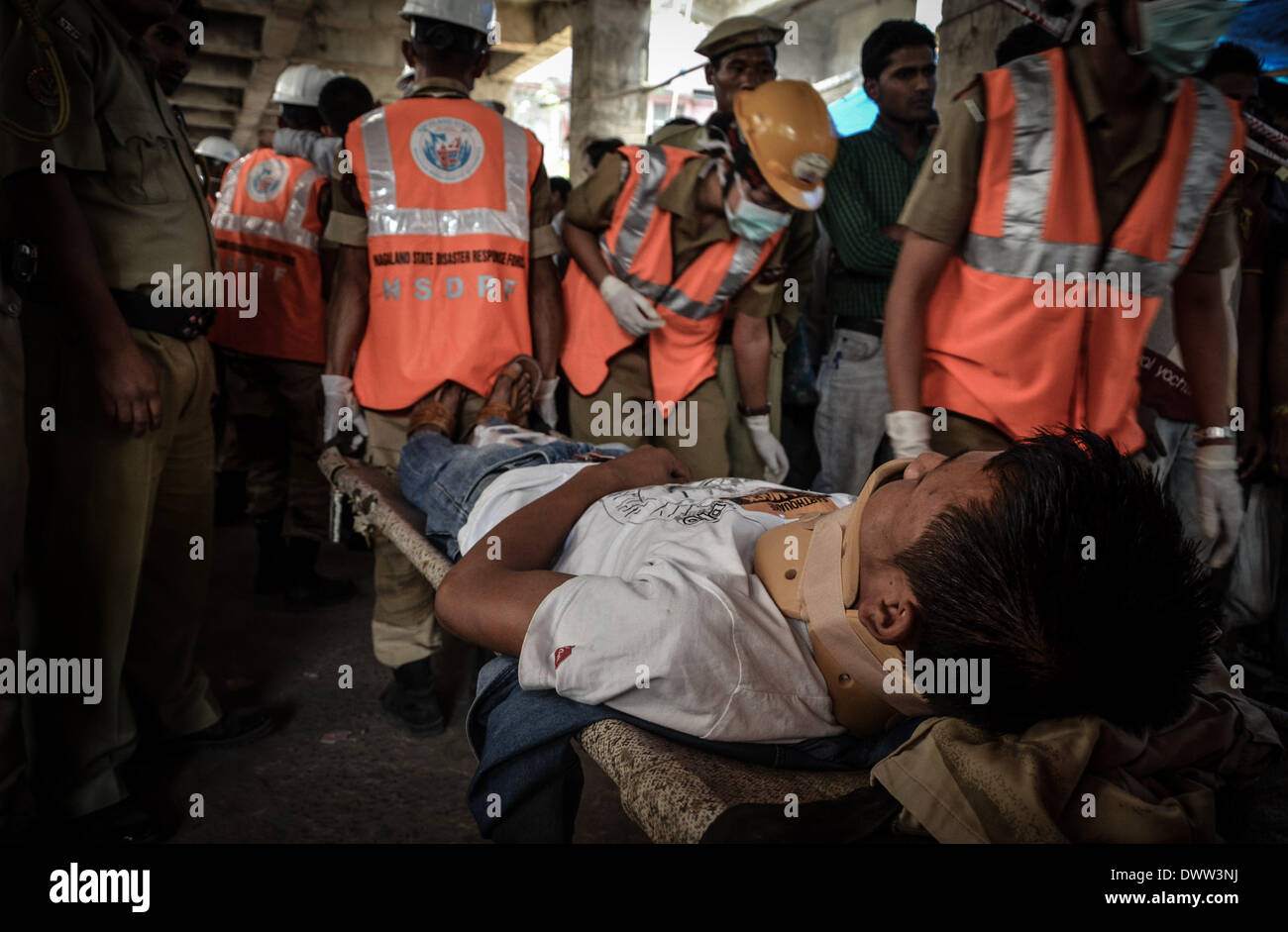 Dimapur, India. 13th Mar, 2014. Nagaland State Disaster Response Force (NSDRF) carries a man in a stretcher pretending to be injured as onlookers watch during an earthquake mock drill in Dimapur, India north eastern state of Nagaland on Thursday, March 13, 2014. The entire north east India are exercising earthquake mock drill, also one of the biggest mock drill in South East Asia aiming to assess multi-state disaster preparedness, for the fear of 1897's 8.7 magnitude Shillong earthquake replication. Credit:  ZUMA Press, Inc./Alamy Live News Stock Photo