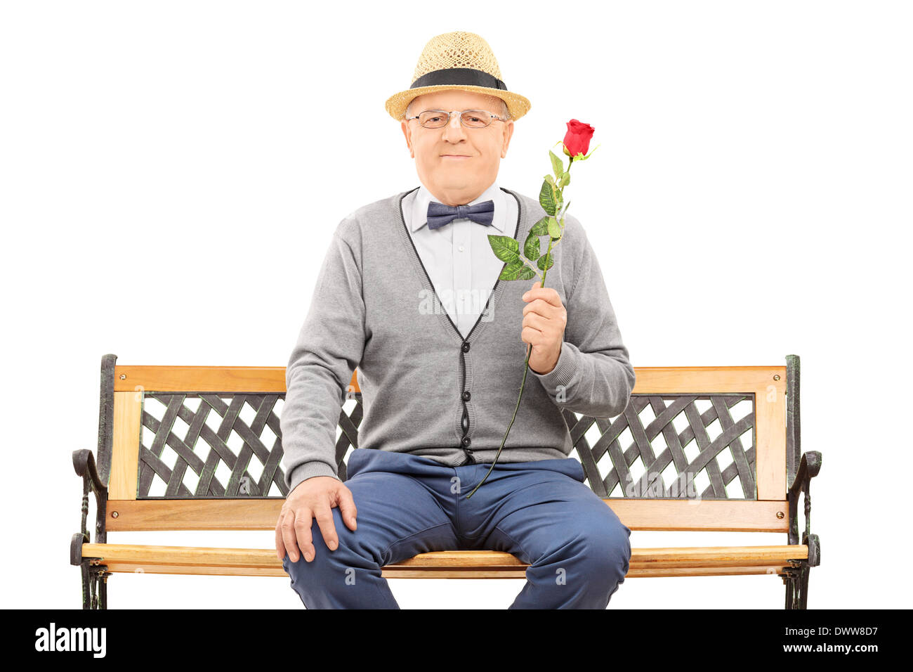 Gentleman holding a red rose seated on bench Stock Photo