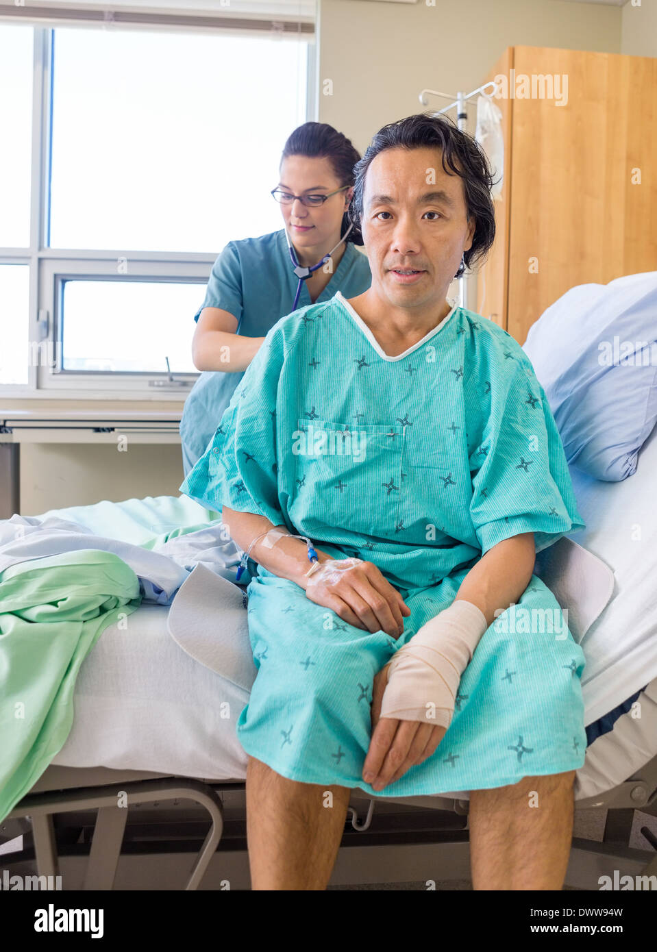 Nurse Examining Patient's Back With Stethoscope On Hospital Bed Stock ...