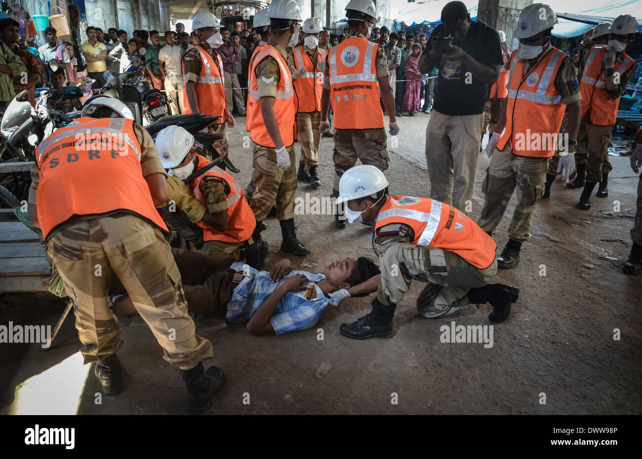 Dimapur, India. 13th Mar, 2014. Nagaland State Disaster Response Force (NSDRF) put out a man pretending to be injured as onlookers watch during an earthquake mock drill in Dimapur, India north eastern state of Nagaland on Thursday, March 13, 2014. The entire north east India are exercising earthquake mock drill, also one of the biggest mock drill in South East Asia aiming to assess multi-state disaster preparedness, for the fear of 1897's 8.7 magnitude Shillong earthquake replication. Credit:  ZUMA Press, Inc./Alamy Live News Stock Photo