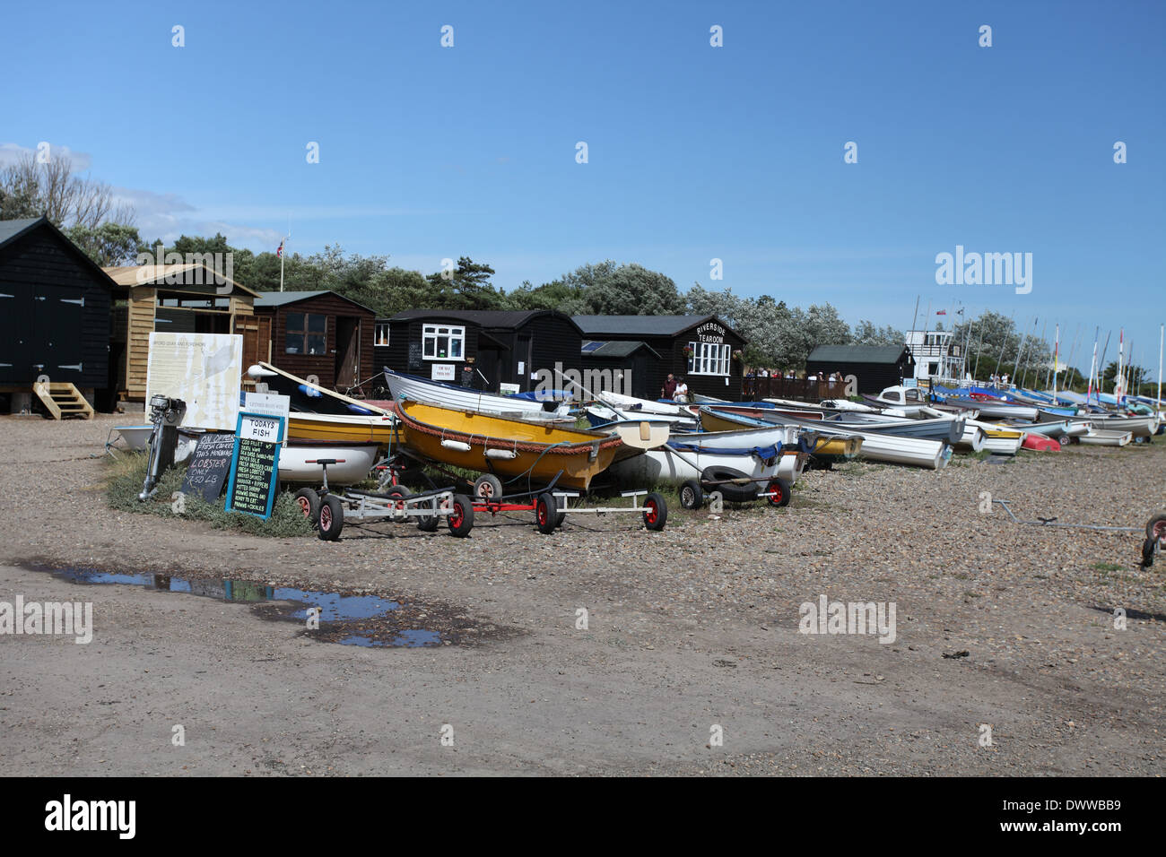 Boats and fishermen huts on the quayside at Orford Quay, Suffolk Stock Photo