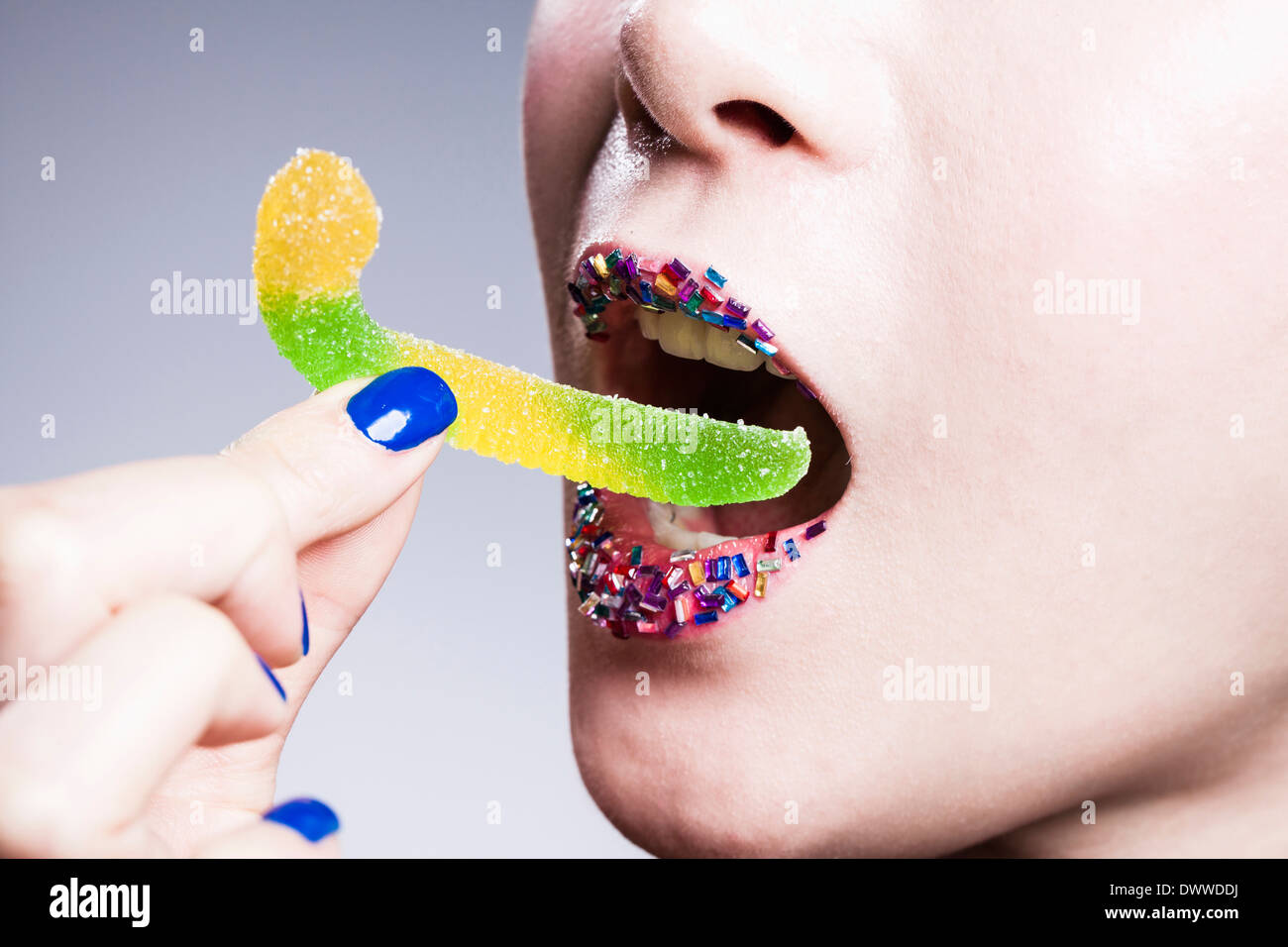 a woman with colorful lips eating candy Stock Photo Alamy