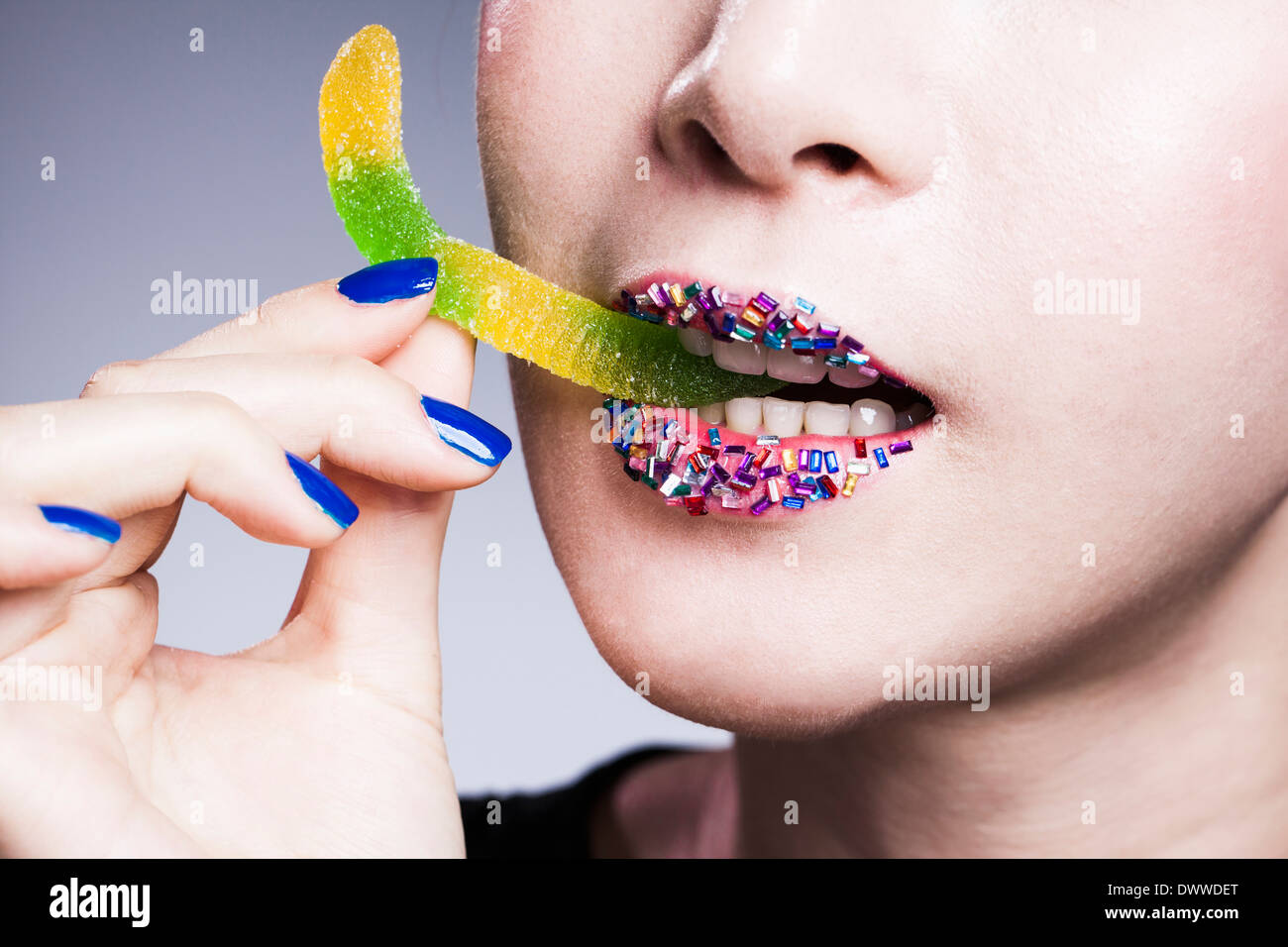 a woman with colorful lips eating candy Stock Photo Alamy