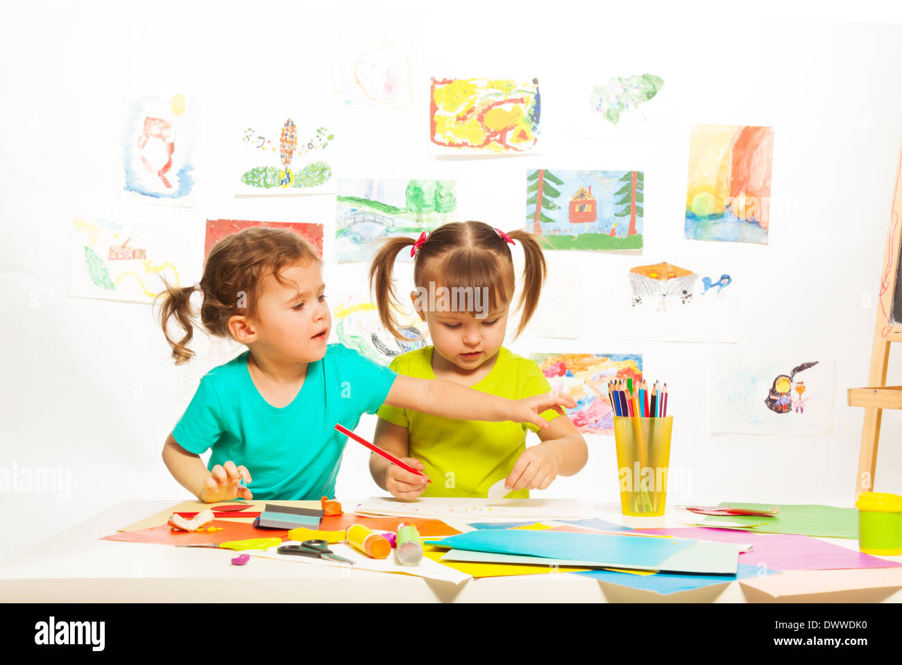 Two little happy girls painting on creative class in kindergarten Stock Photo