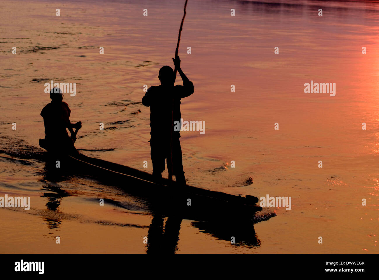 Zambian fishermen in a makoro canoe at dawn on the Zambezi river. Stock Photo