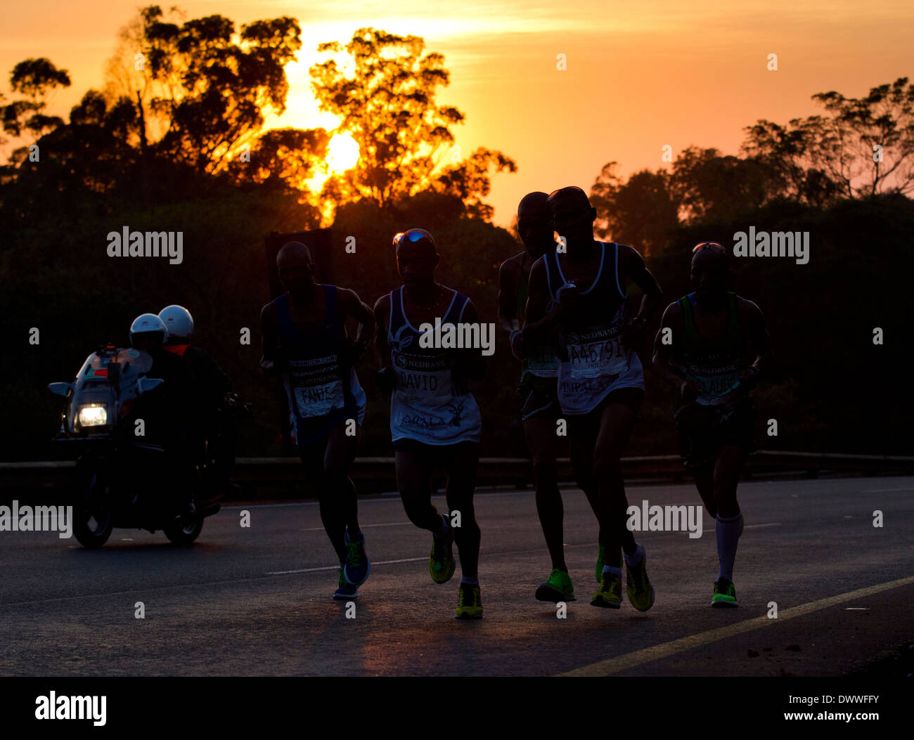 Runners are tracked by a motorcycle up Fields Hill during the Comrades Marathon, 2 June 2013. The Comrades is run between the Stock Photo