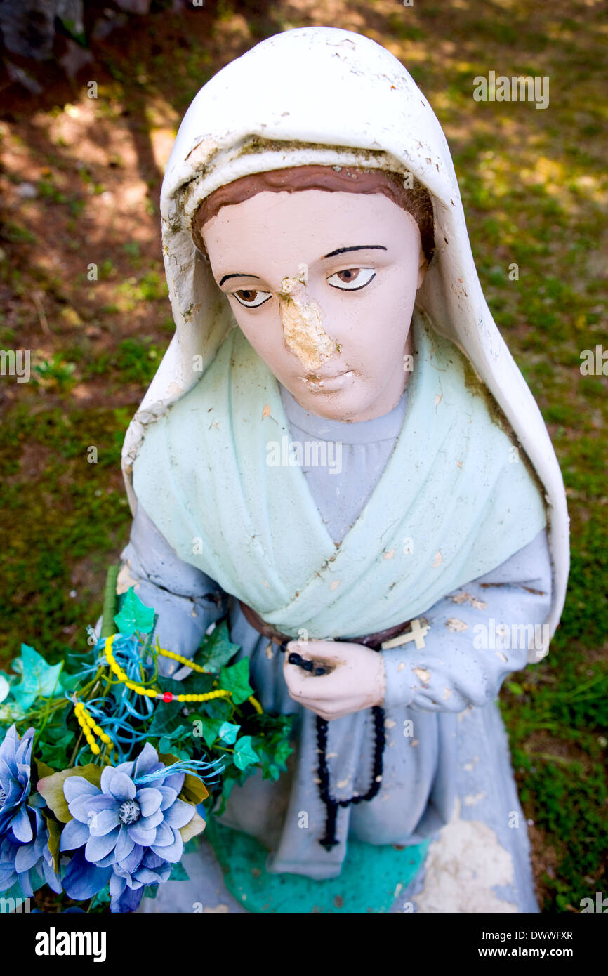 A statue of the Virgin Mary with a damaged face. Stock Photo